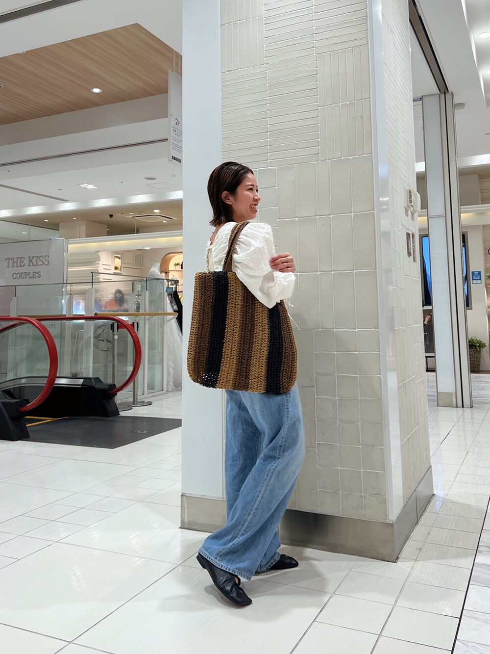 ホワイト系のシャツ/ブラウス、ブラウン系のトートバッグ、ブルー系のデニムパンツを着用したレディースの冬コーディネートの3枚目の写真