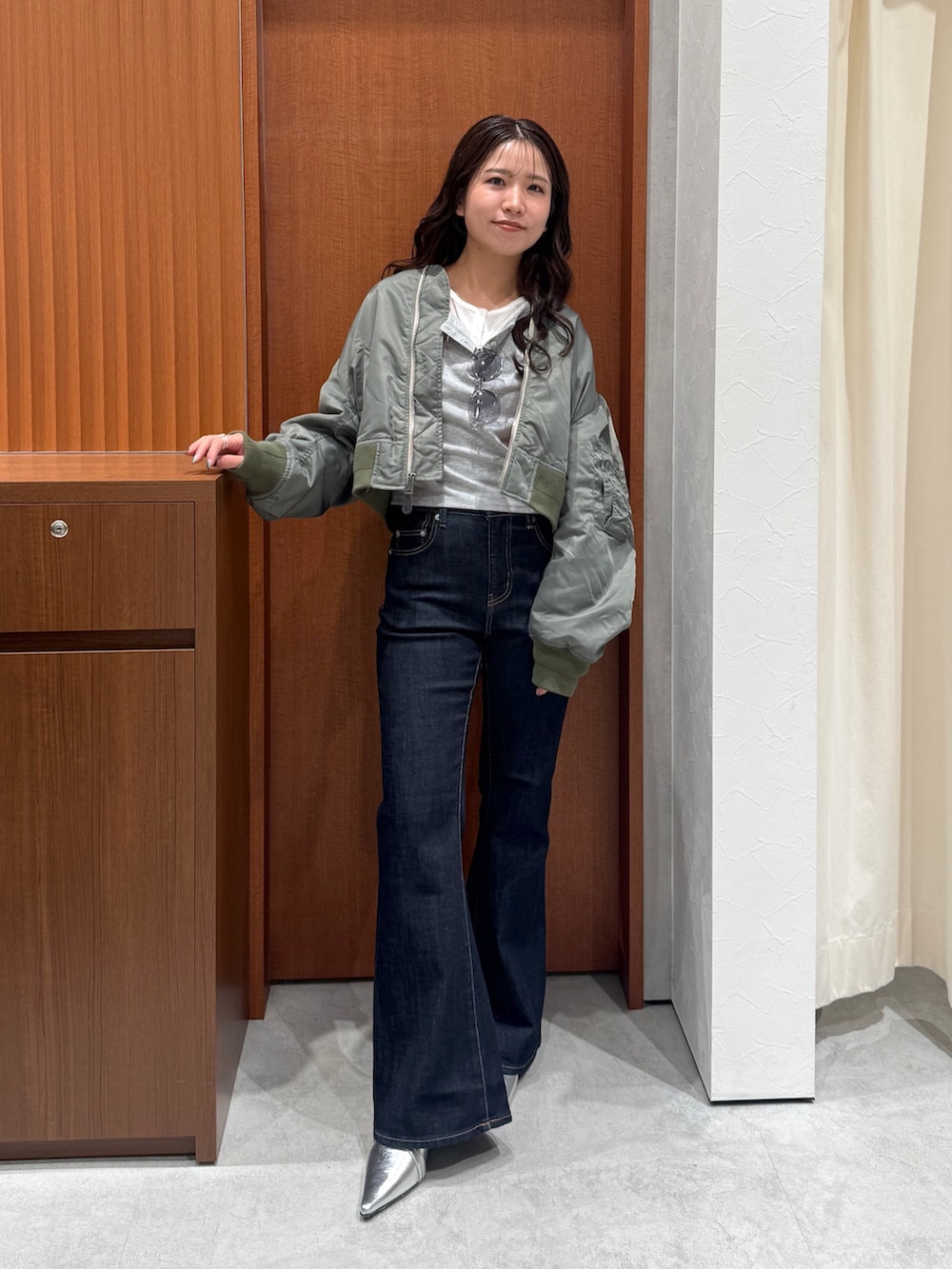 ブルー系のデニムパンツ、グレー系のTシャツ/カットソー、グリーン系のMA-1を着用したレディースの秋コーディネートの5枚目の写真
