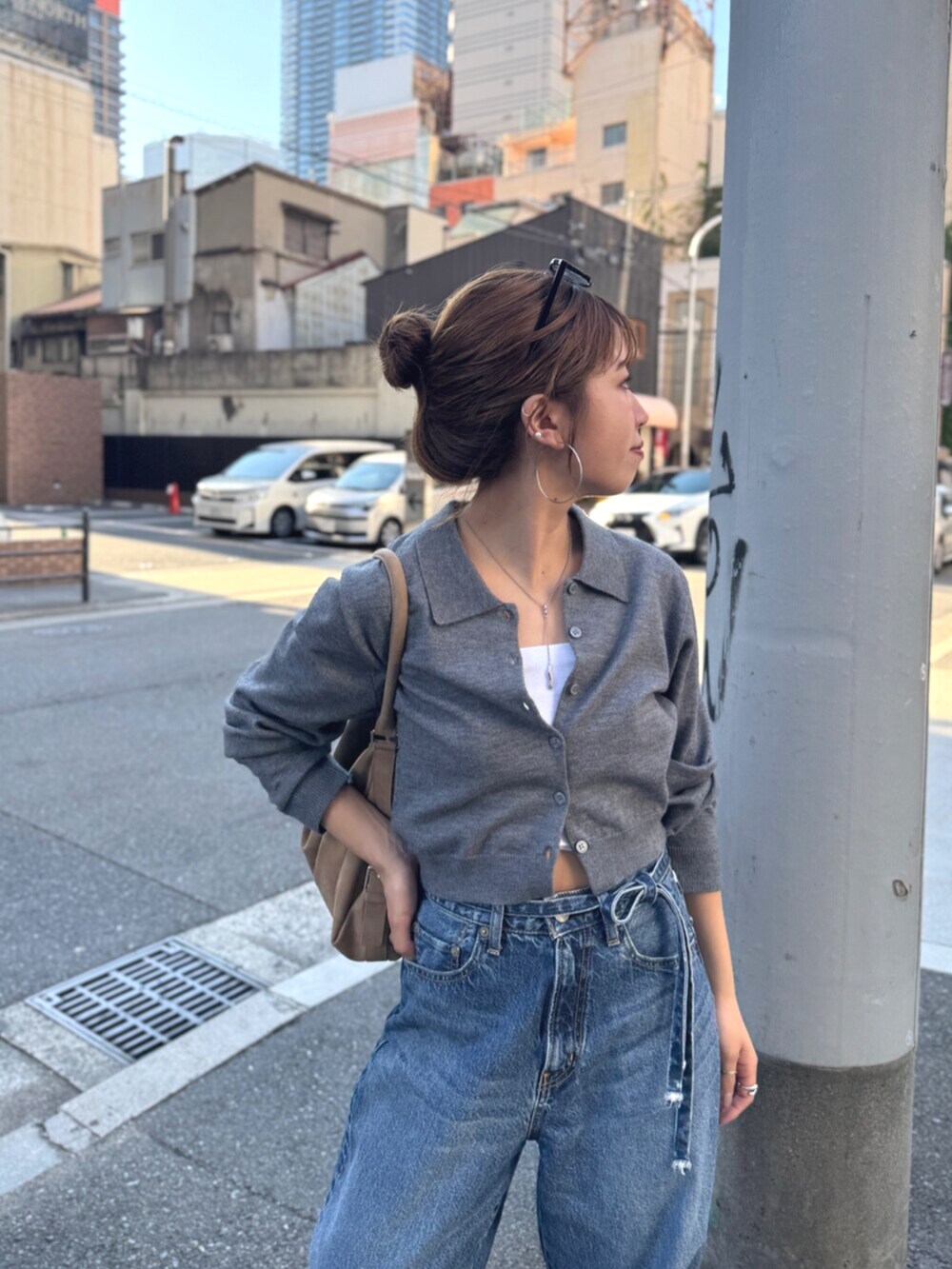 ベージュ系のスリッポン、グレー系のカーディガン/ボレロ、ブルー系のデニムパンツを着用したレディースの夏コーディネートの9枚目の写真