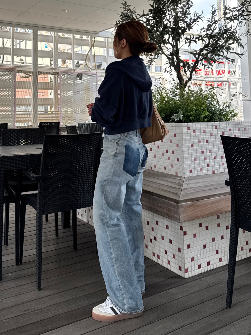 ブルー系のパーカー、ブルー系のデニムパンツ、シルバー系のネックレスを着用したレディースの冬コーディネートの3枚目の写真