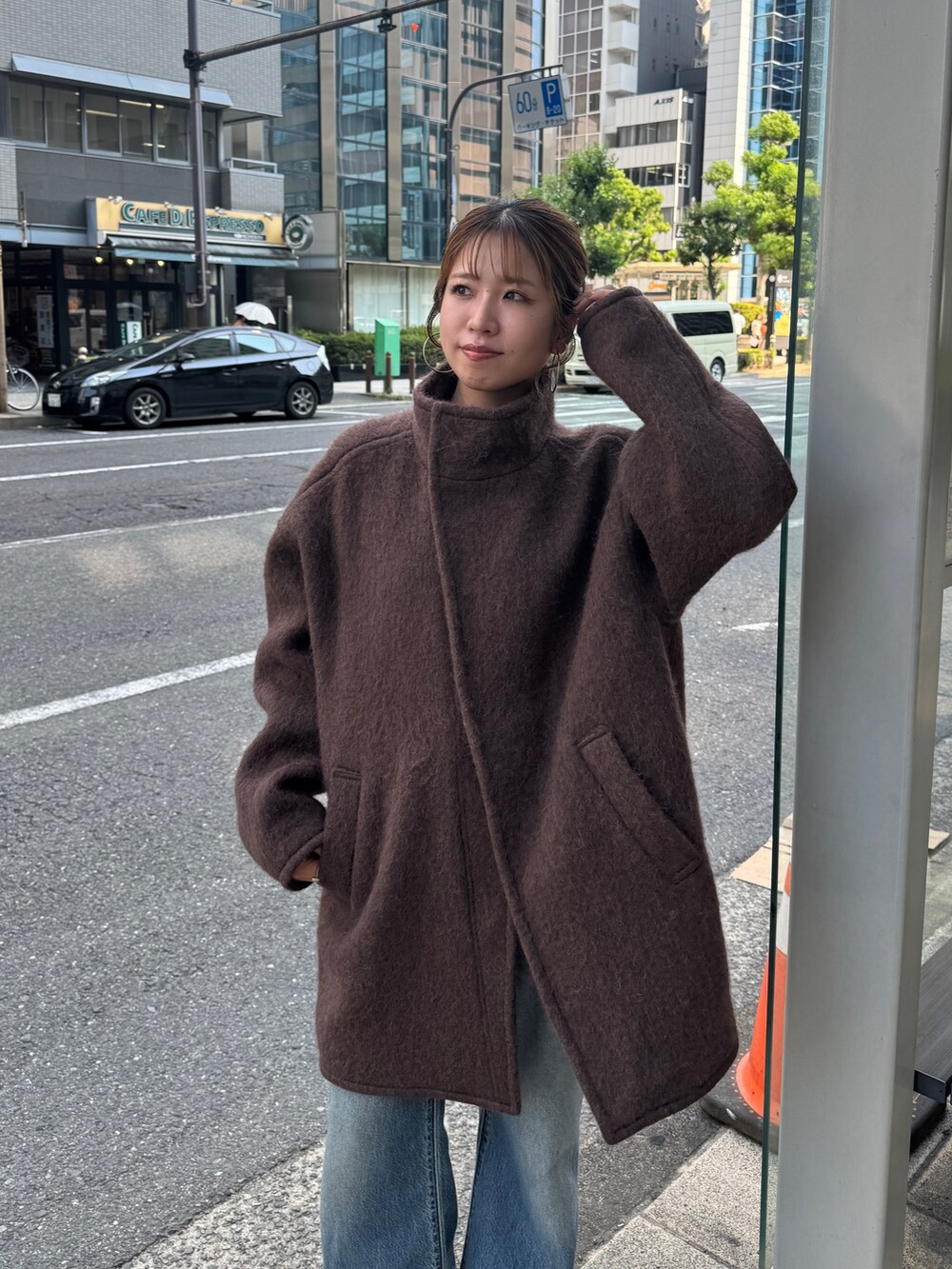 ブラウン系のダウンジャケット/コート、ブルー系のデニムパンツ、ブラウン系のブーツを着用したレディースの秋コーディネートの7枚目の写真