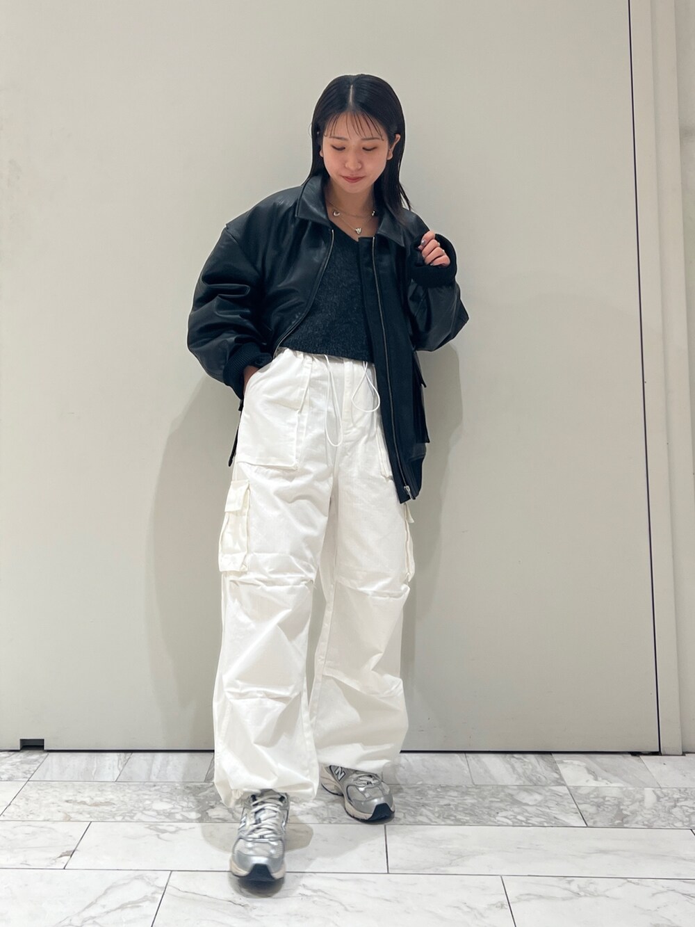 グレー系のニット/セーター、ホワイト系のカーゴパンツ、ブラック系のブルゾンを着用したレディースの秋コーディネートの3枚目の写真