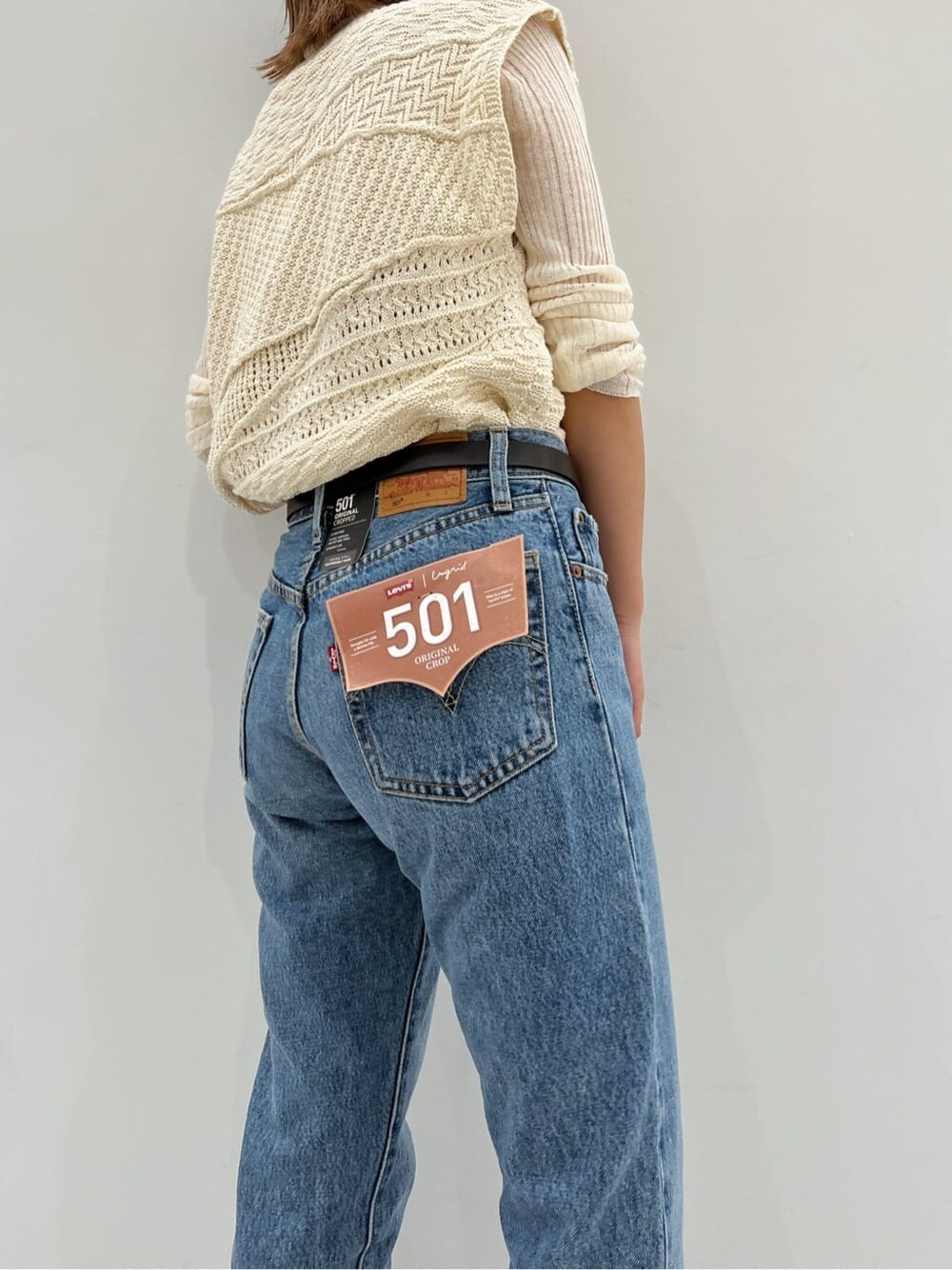 ブラック系のブーツ、ホワイト系のニット/セーター、ホワイト系のニット/セーターを着用したレディースの夏コーディネートの6枚目の写真