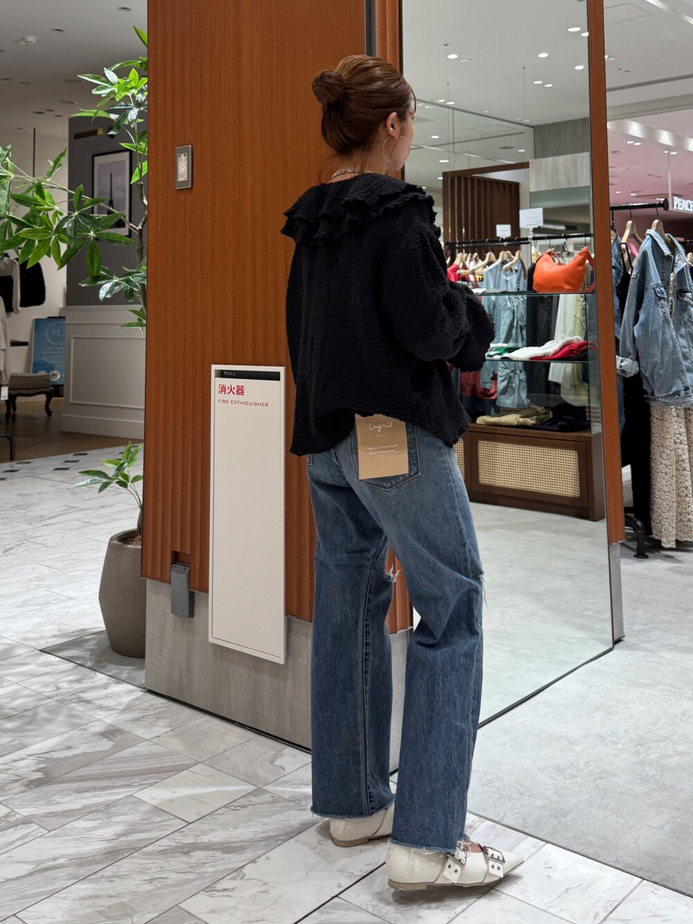 ブルー系のデニムパンツ、ブラック系のシャツ/ブラウス、ホワイト系のパンプスを着用したレディースの春コーディネートの3枚目の写真