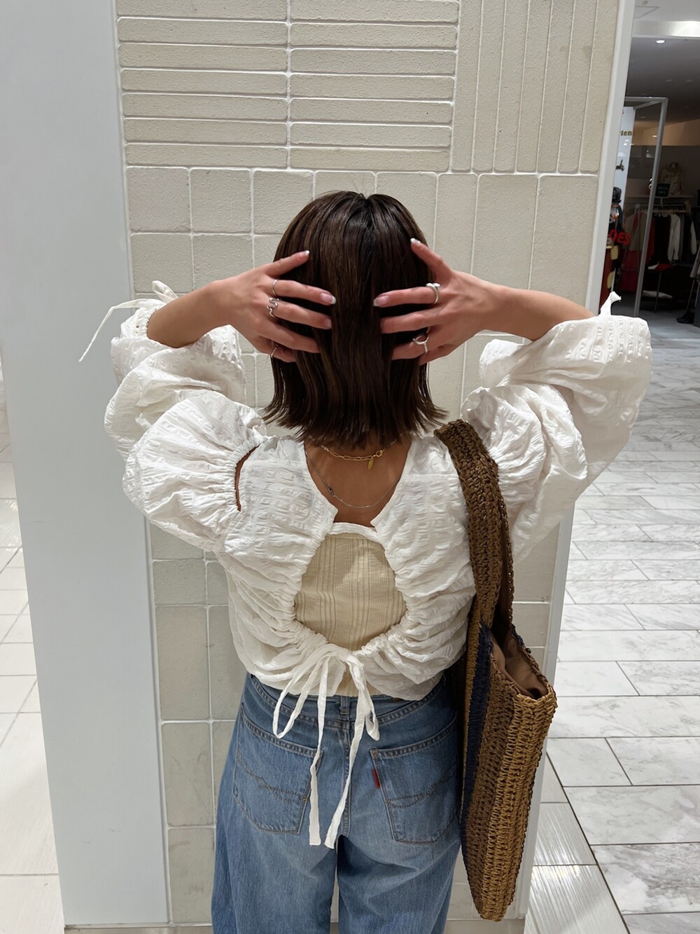 ホワイト系のシャツ/ブラウス、ブラウン系のトートバッグ、ブルー系のデニムパンツを着用したレディースの冬コーディネートの10枚目の写真