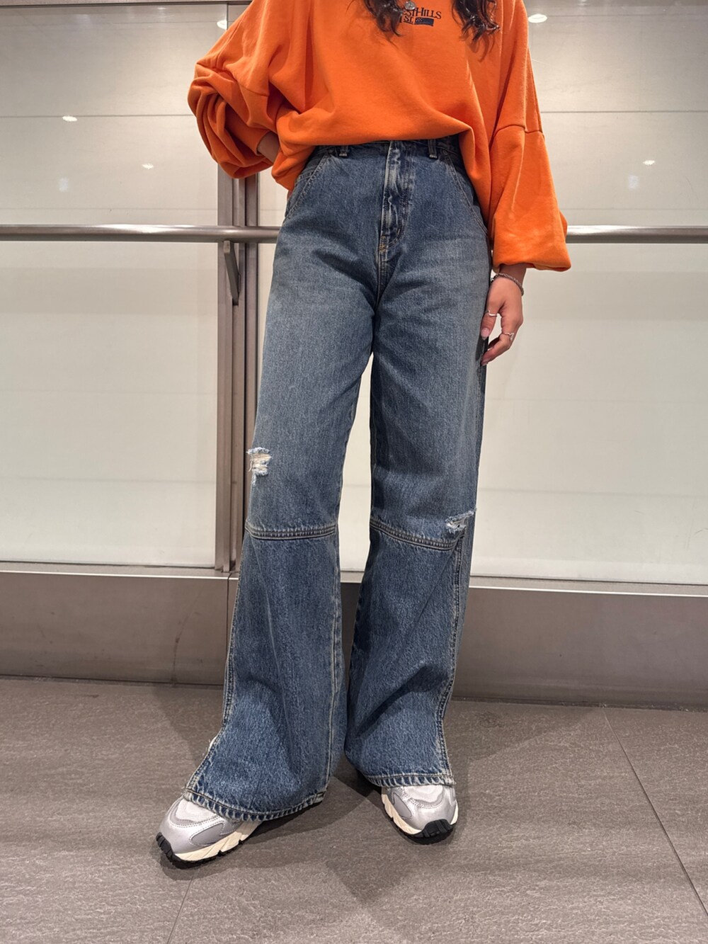 ブルー系のデニムパンツ、オレンジ系のスウェットを着用したレディースの冬コーディネートの8枚目の写真