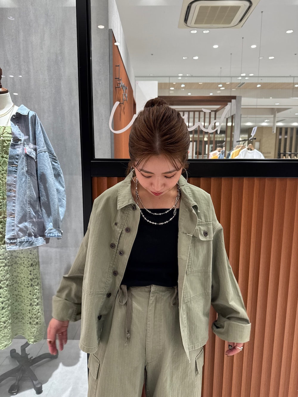 グリーン系のミリタリージャケット、ブラック系のキャミソール、グリーン系のその他パンツを着用したレディースの春コーディネートの7枚目の写真