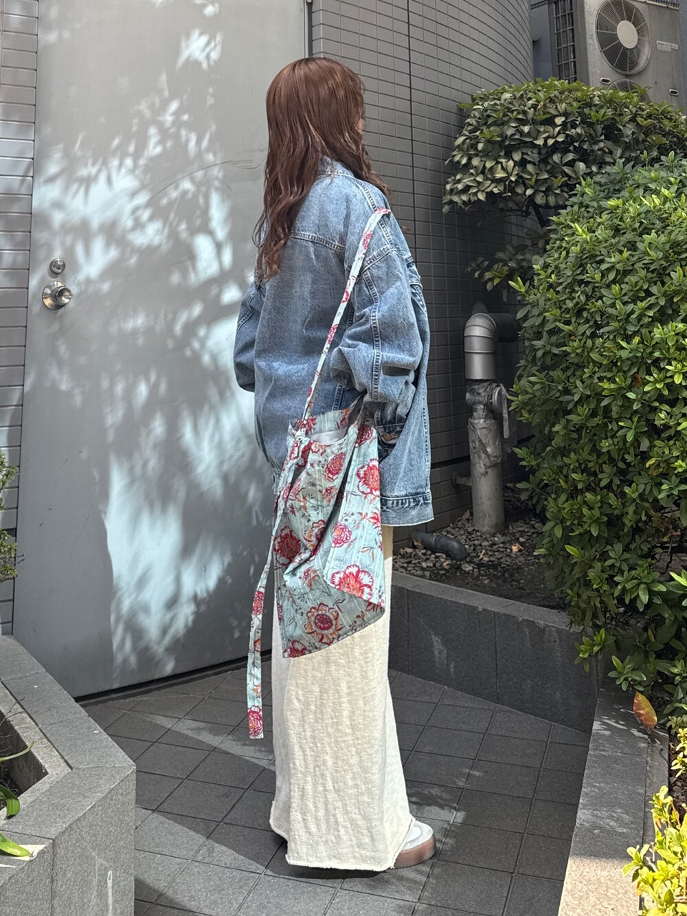 グリーン系のショルダーバッグ、ブルー系のデニムジャケット、グレー系のスウェットを着用したレディースの冬コーディネートの4枚目の写真