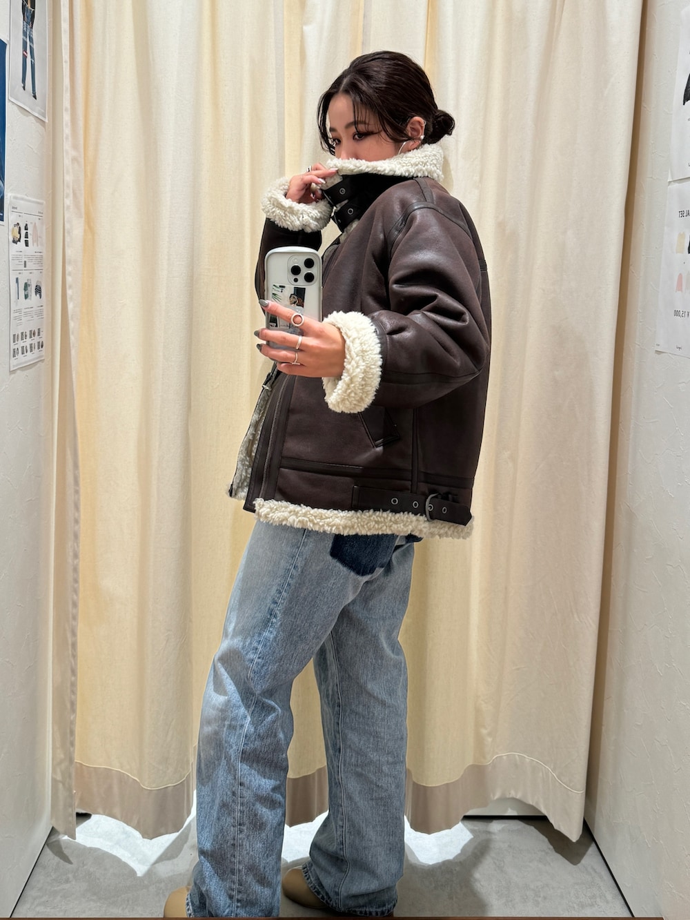 ブルー系のデニムパンツ、ブラウン系のブルゾン、ホワイト系のニット/セーターを着用したレディースの秋コーディネートの7枚目の写真