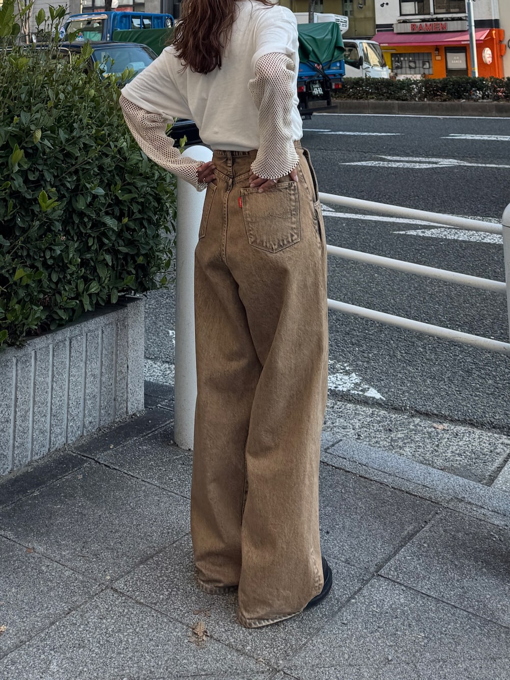 ブラウン系のデニムパンツ、ホワイト系のTシャツ/カットソー、ホワイト系のTシャツ/カットソーを着用したレディースの冬コーディネートの3枚目の写真