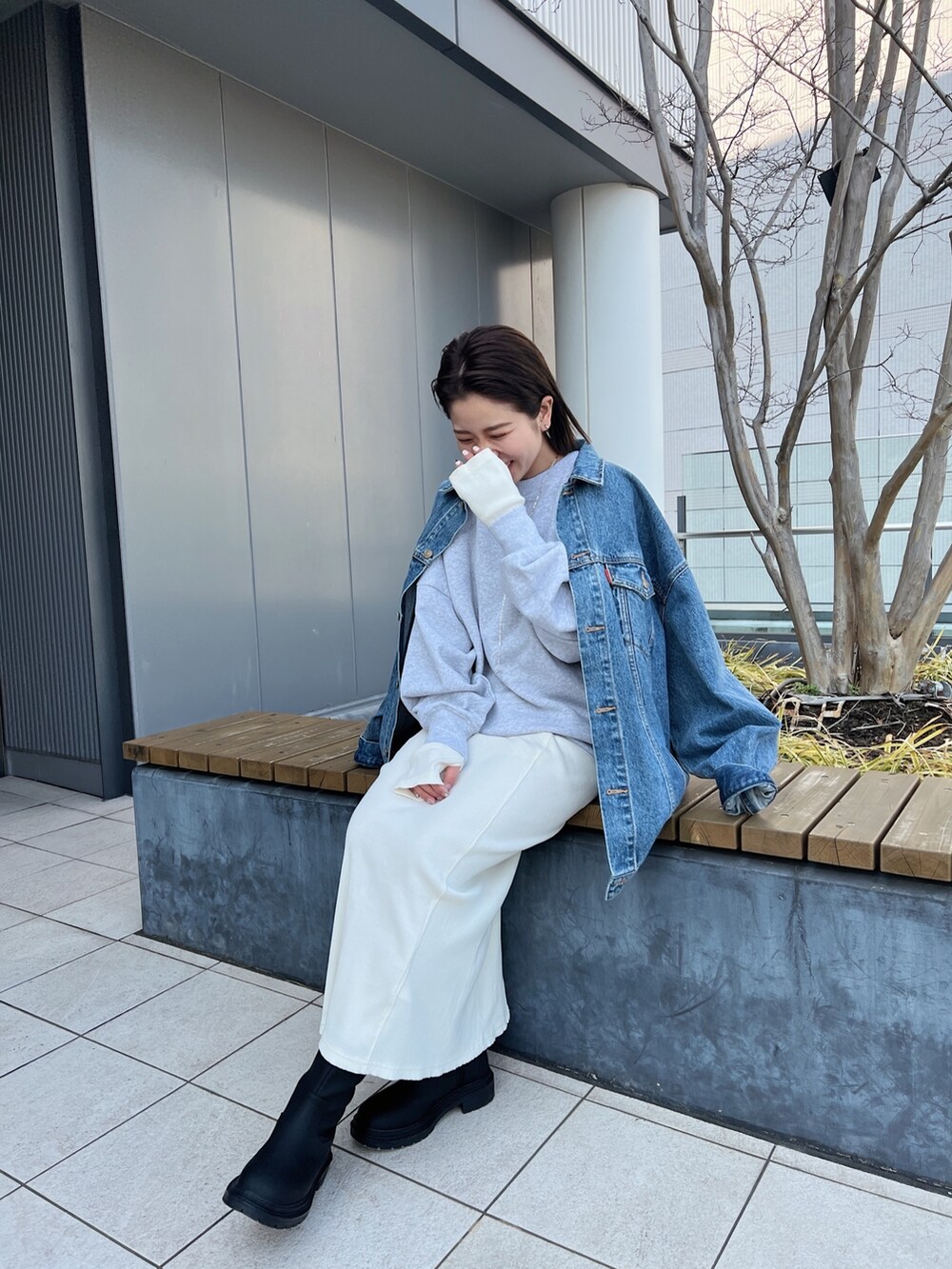 ブルー系のデニムジャケット、グレー系のスウェット、ホワイト系のワンピースを着用したレディースの冬コーディネートの8枚目の写真