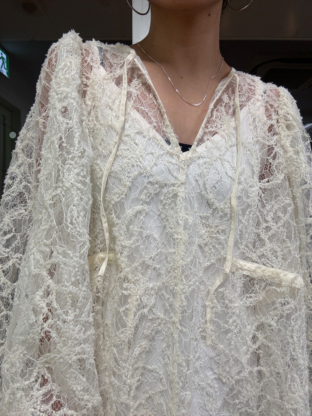 ベージュ系のブルゾン、ホワイト系のワンピース、ブルー系のデニムパンツを着用したレディースの冬コーディネートの10枚目の写真