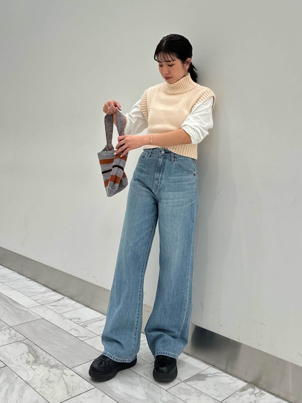ホワイト系のワンピース、ホワイト系のTシャツ/カットソー、グレー系のハンドバッグを着用したレディースの冬コーディネートの6枚目の写真