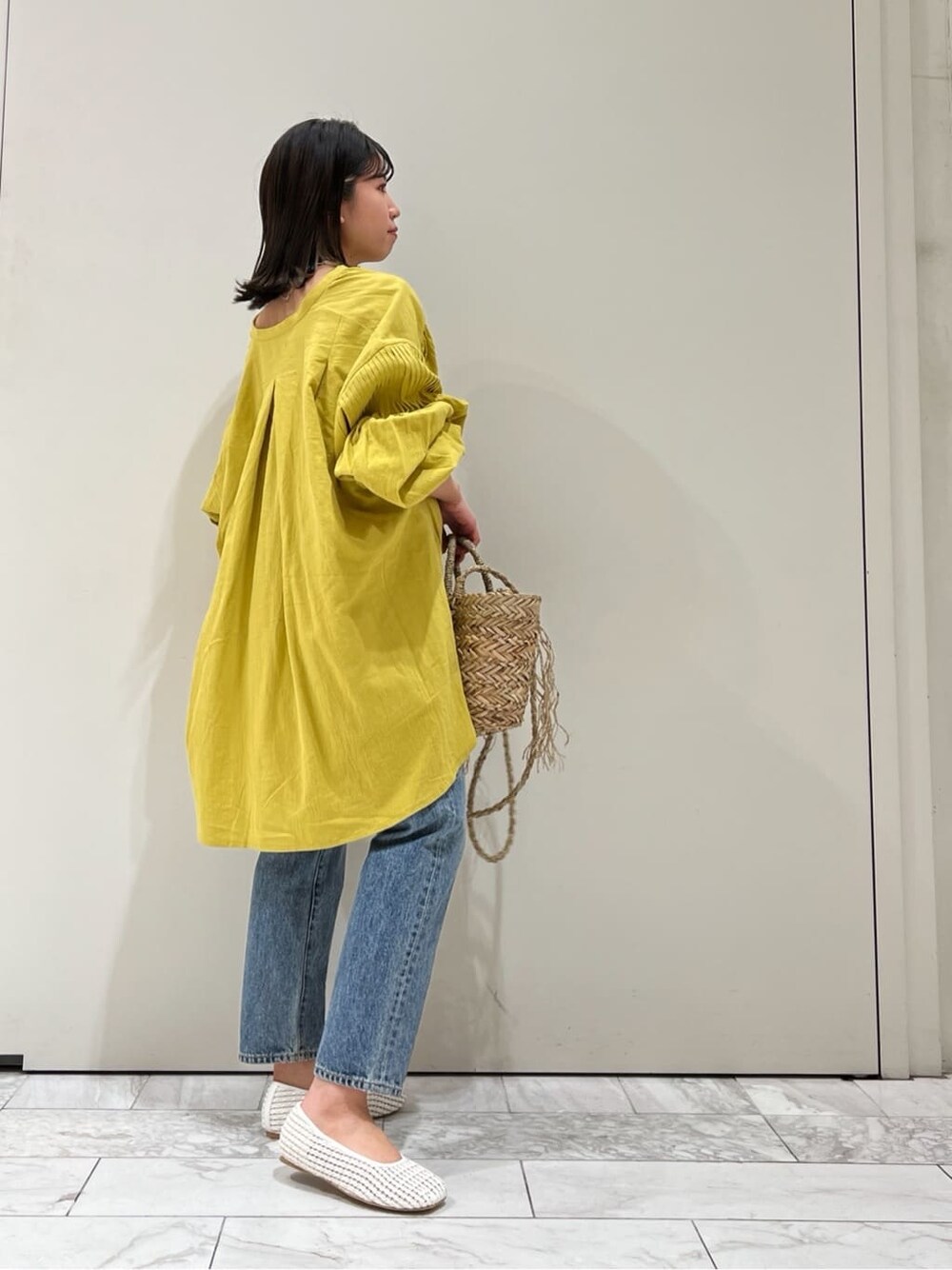 ホワイト系のパンプス、イエロー系のシャツ/ブラウス、ベージュ系のかごバッグを着用したレディースの春コーディネートの4枚目の写真