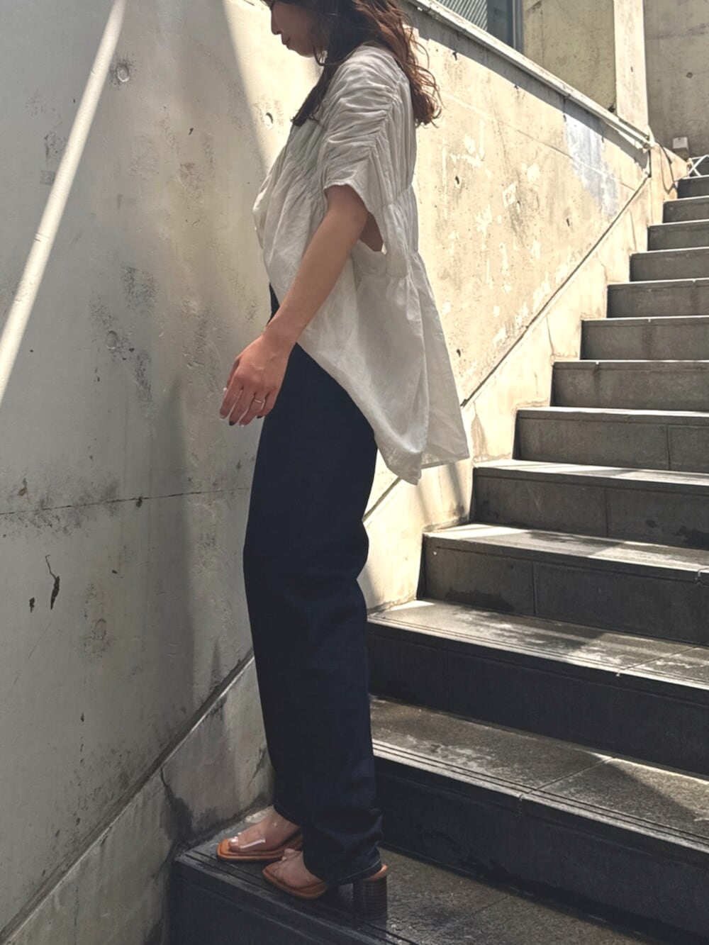 ブルー系のデニムパンツ、その他のサンダル、ホワイト系のシャツ/ブラウスを着用したレディースの春コーディネートの3枚目の写真