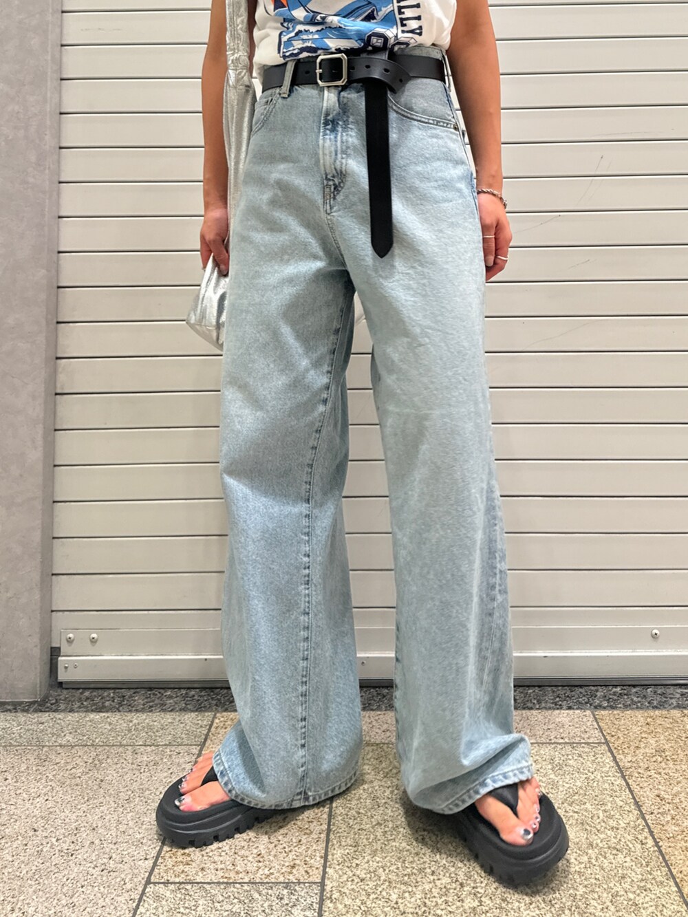 ブルー系のデニムパンツ、ホワイト系のTシャツ/カットソー、ブラック系のベルトを着用したレディースの夏コーディネートの9枚目の写真