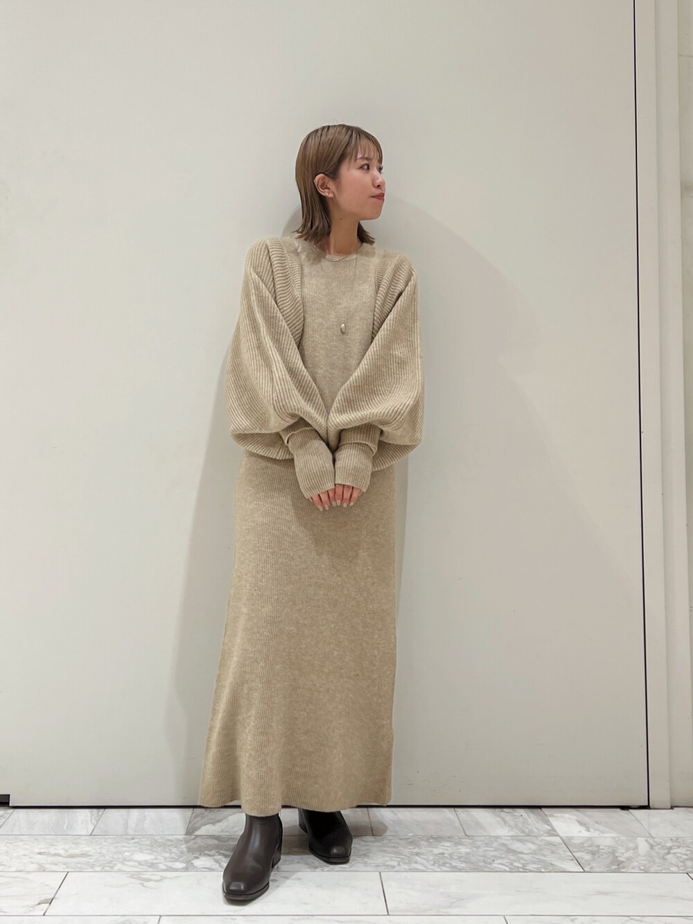 グレー系のワンピース、ブラウン系のブーツを着用したレディースの秋コーディネートの4枚目の写真