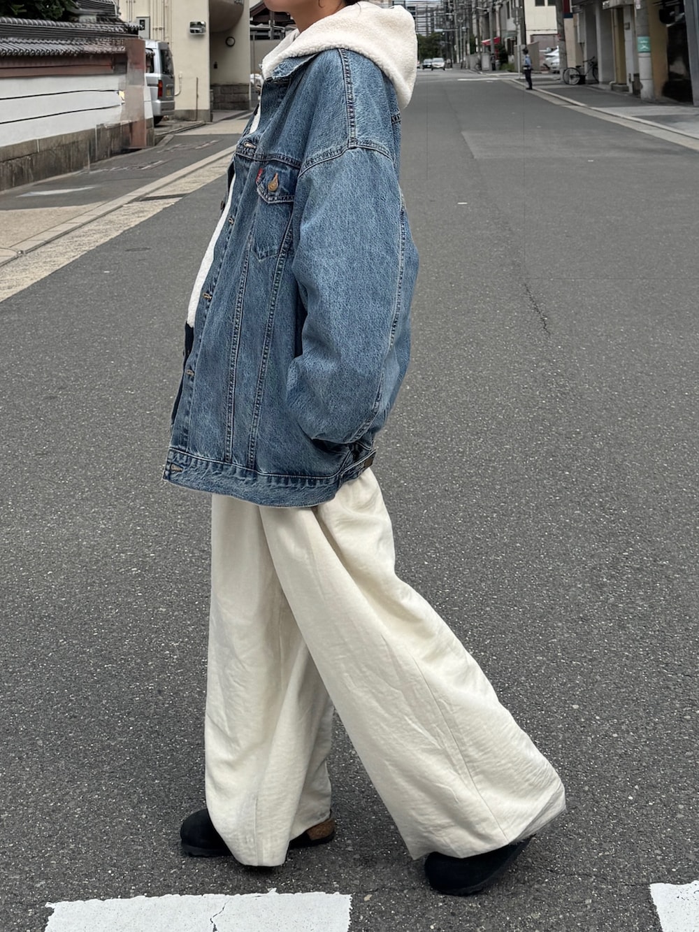 ブルー系のデニムジャケット、ホワイト系のパーカー、ホワイト系のその他パンツを着用したレディースの秋コーディネートの4枚目の写真