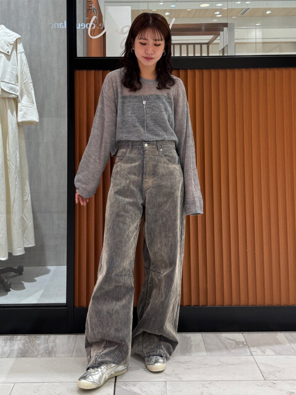 ベージュ系のデニムパンツ、グレー系のニット/セーターを着用したレディースの秋コーディネートの2枚目の写真