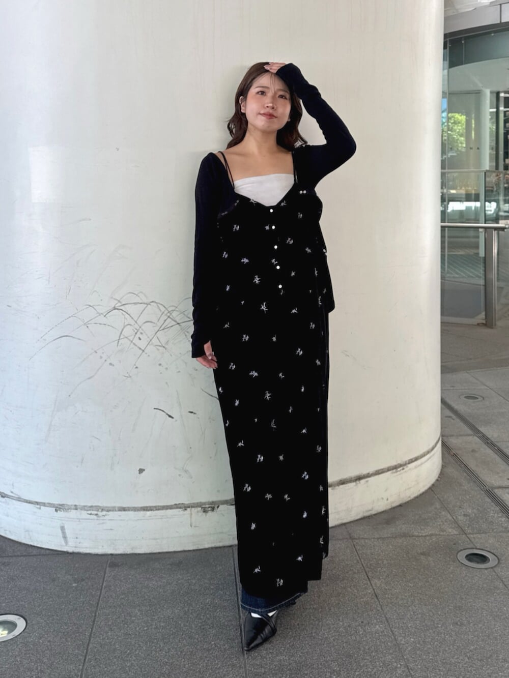 ブルー系のデニムパンツ、ブラック系のパンプス、ブラック系のワンピースを着用したレディースの秋コーディネートの2枚目の写真