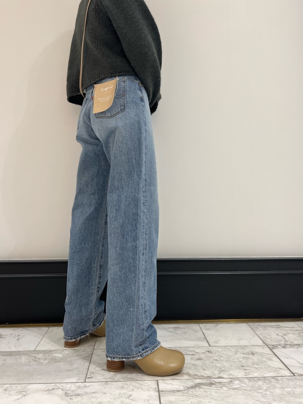 ブルー系のデニムパンツ、グレー系のニット/セーター、ベージュ系のブーツを着用したレディースの秋コーディネートの8枚目の写真