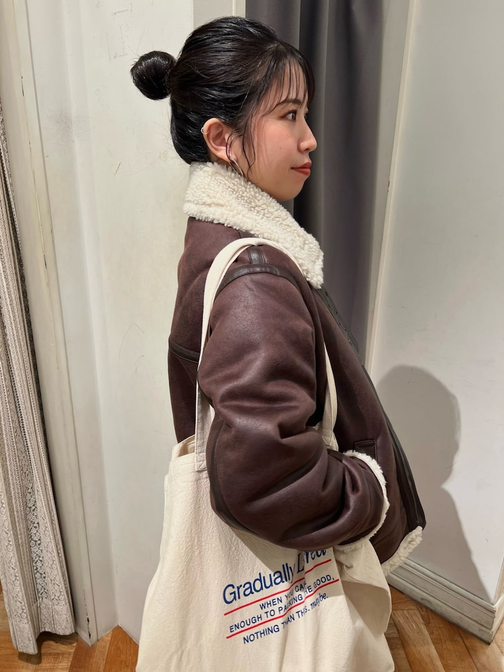 オレンジ系のニット/セーター、ホワイト系のTシャツ/カットソー、ブルー系のデニムパンツを着用したレディースの冬コーディネートの9枚目の写真