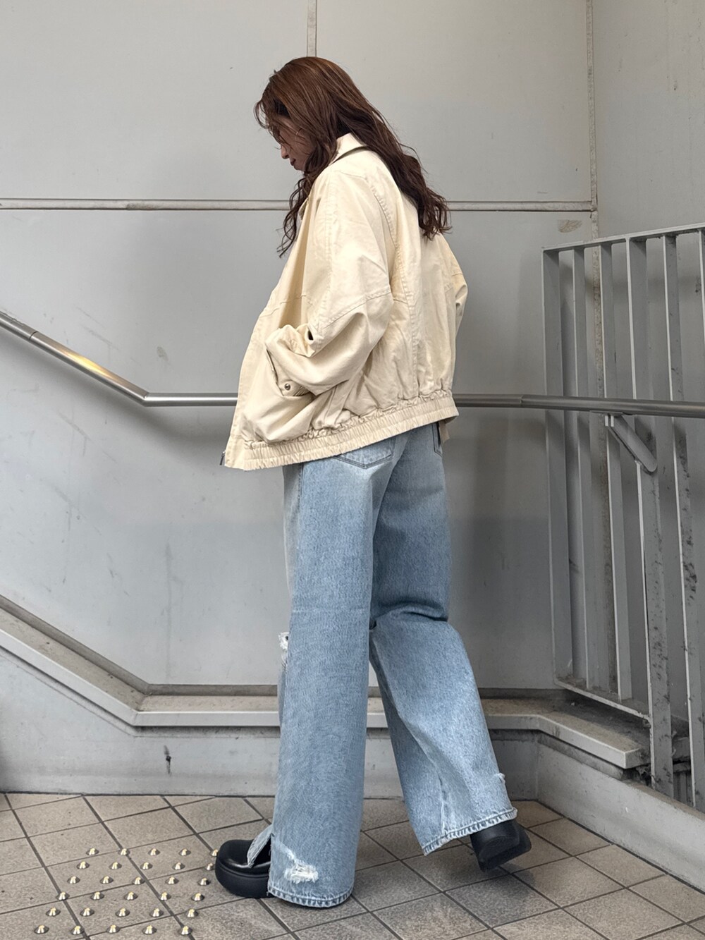 ブルー系のデニムパンツ、ベージュ系のブルゾン、ホワイト系のTシャツ/カットソーを着用したレディースの冬コーディネートの5枚目の写真