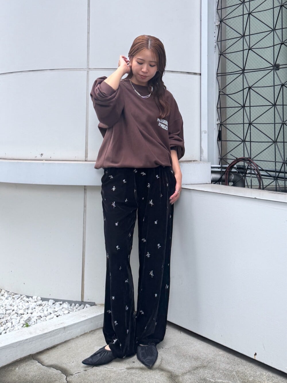ブラウン系のスウェット、ブラック系のその他パンツ、ブラック系のその他シューズを着用したレディースの夏コーディネートの2枚目の写真