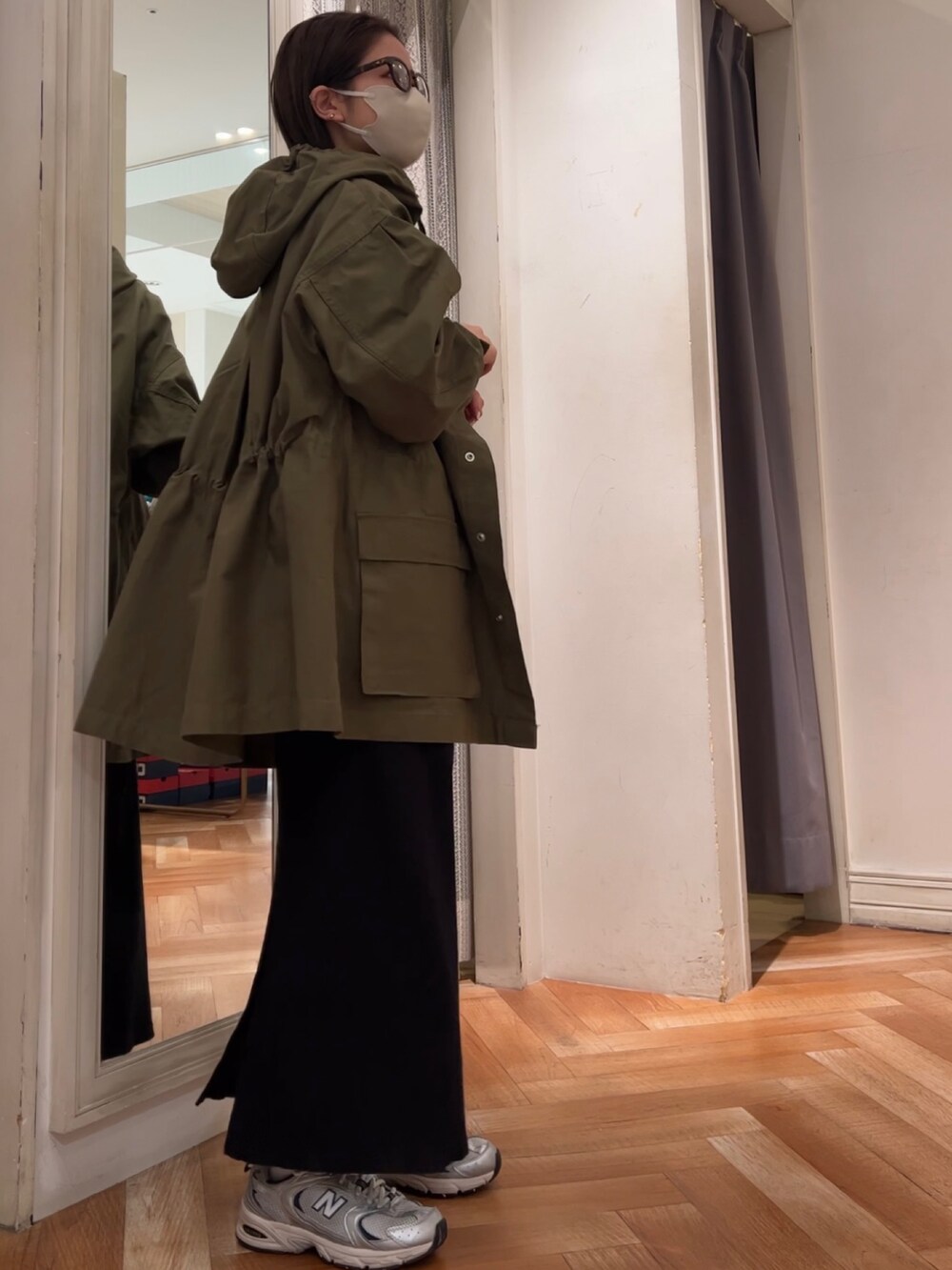 ブラック系のワンピース、グリーン系のブルゾン、ブラウン系のメガネを着用したレディースの冬コーディネートの5枚目の写真