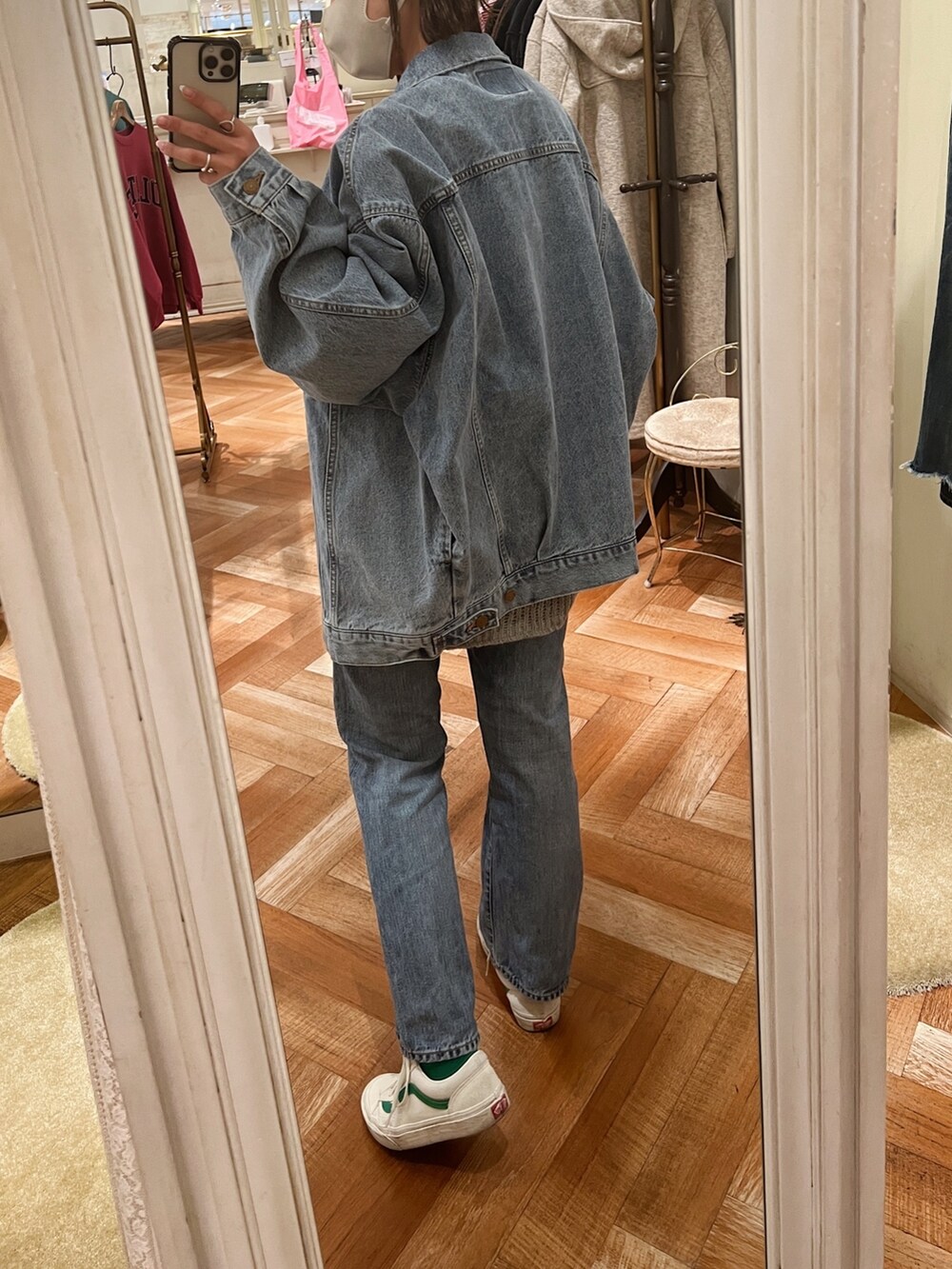 ホワイト系のデニムジャケット、グレー系のニット/セーター、ブルー系のデニムパンツを着用したレディースの冬コーディネートの5枚目の写真