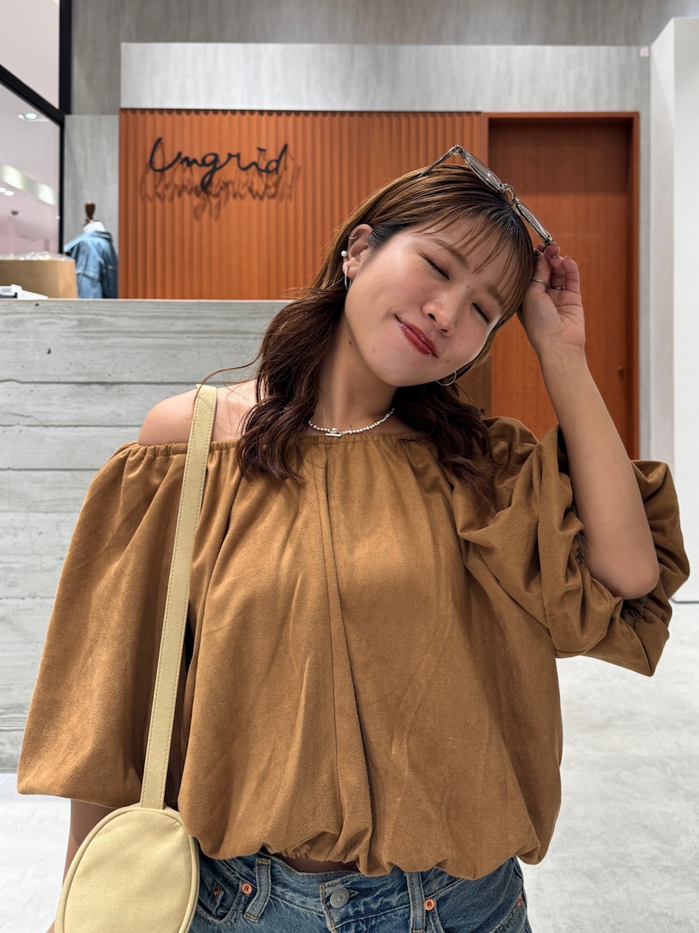 ブルー系のデニムパンツ、イエロー系のシャツ/ブラウス、ブラウン系のサングラスを着用したレディースの夏コーディネートの9枚目の写真