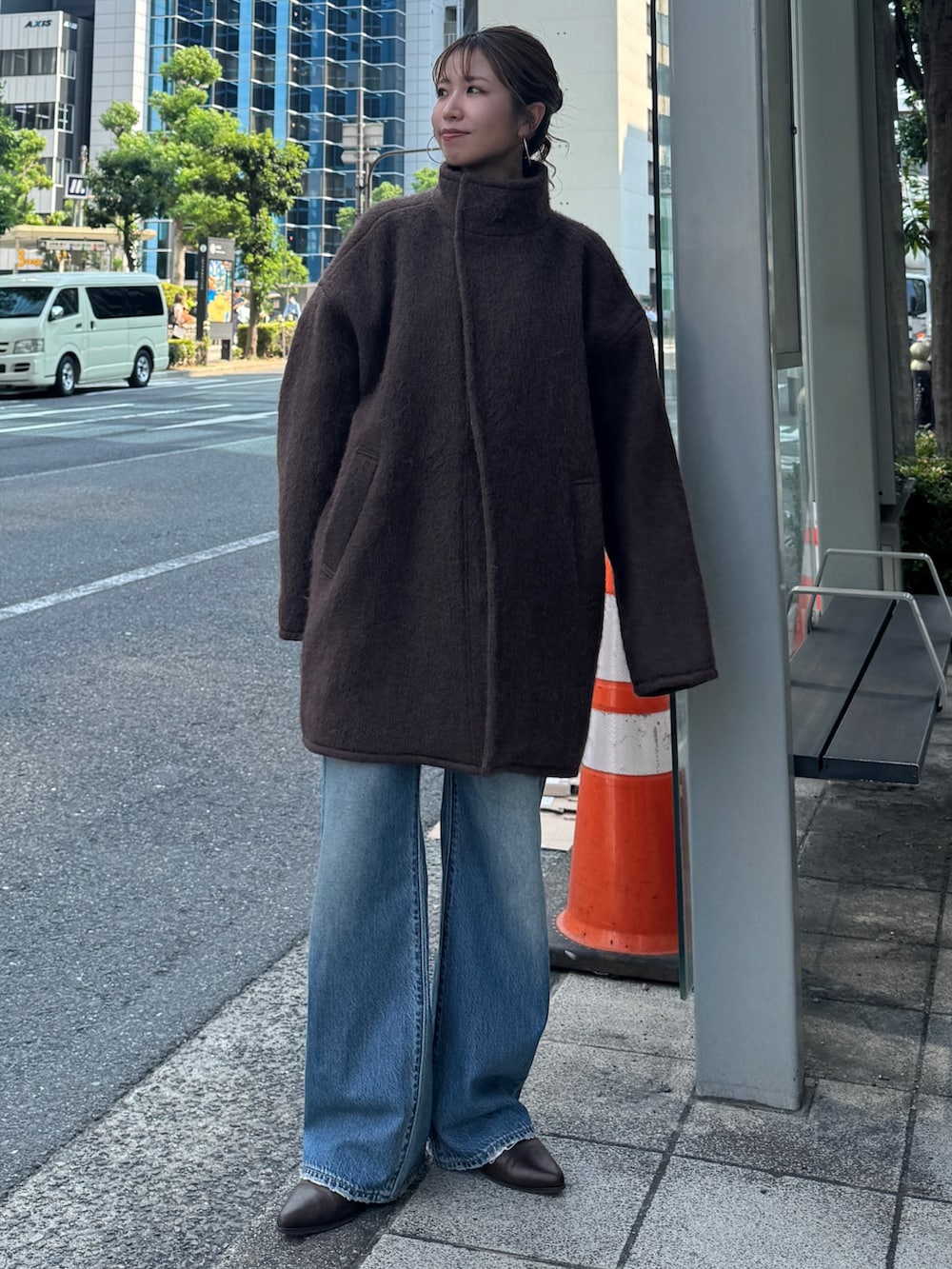 ブラウン系のダウンジャケット/コート、ブルー系のデニムパンツ、ブラウン系のブーツを着用したレディースの秋コーディネートの2枚目の写真