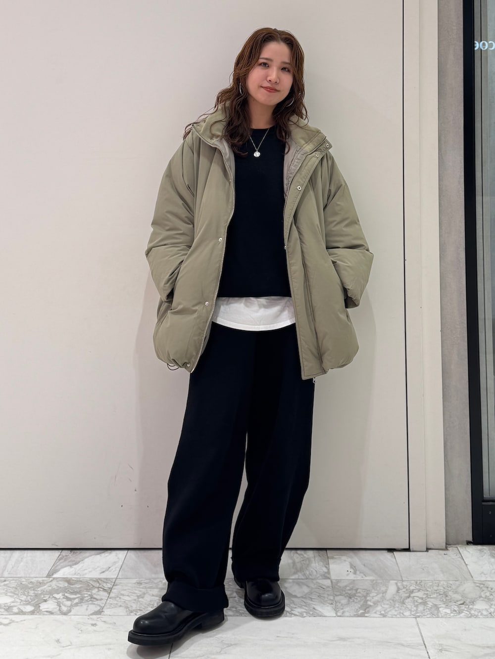 ブラック系のニット/セーター、ホワイト系のTシャツ/カットソー、ブラック系のその他パンツを着用したレディースの冬コーディネートの2枚目の写真