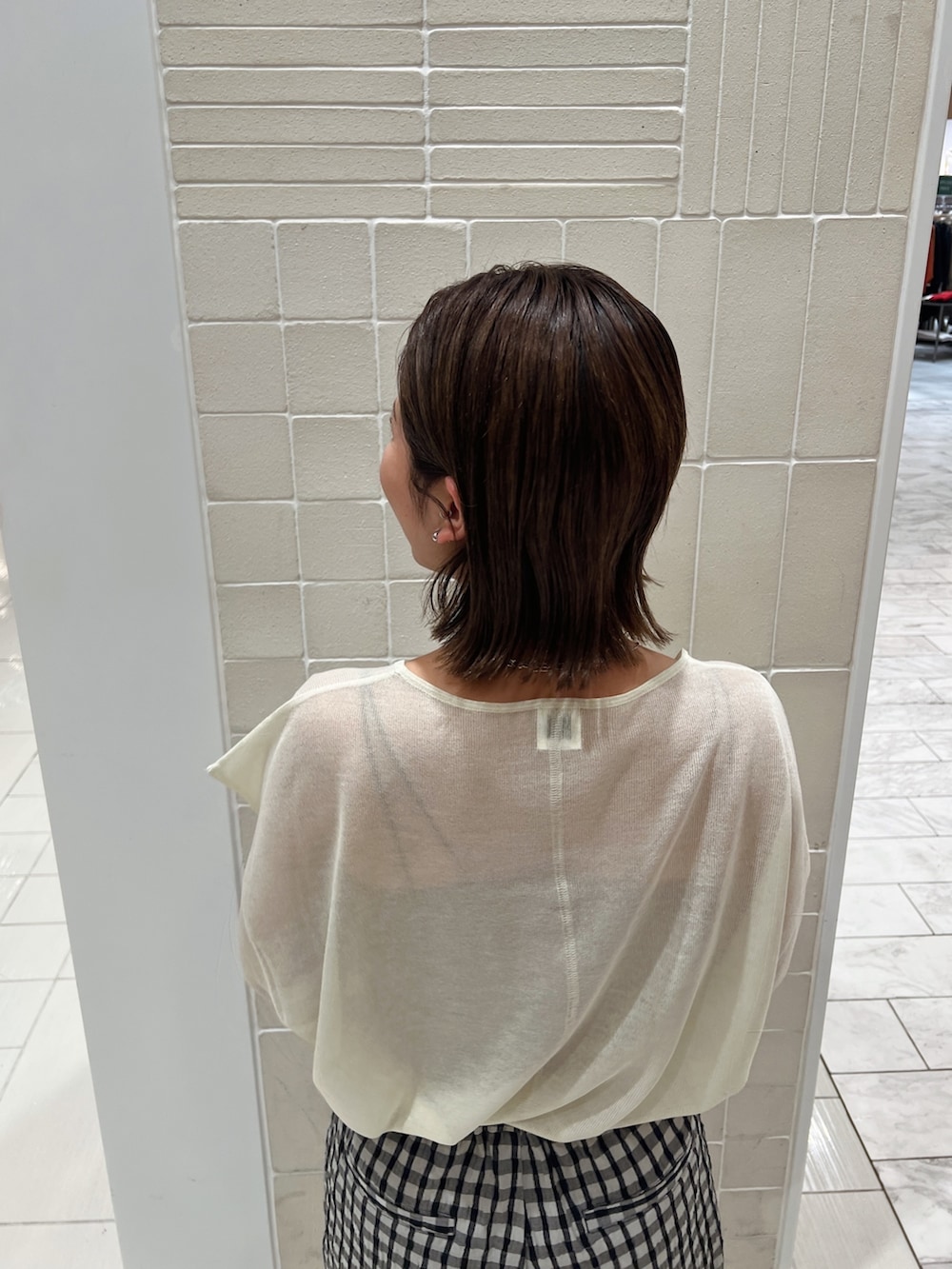 イエロー系のニット/セーター、イエロー系のパンプス、グレー系のその他パンツを着用したレディースの冬コーディネートの10枚目の写真