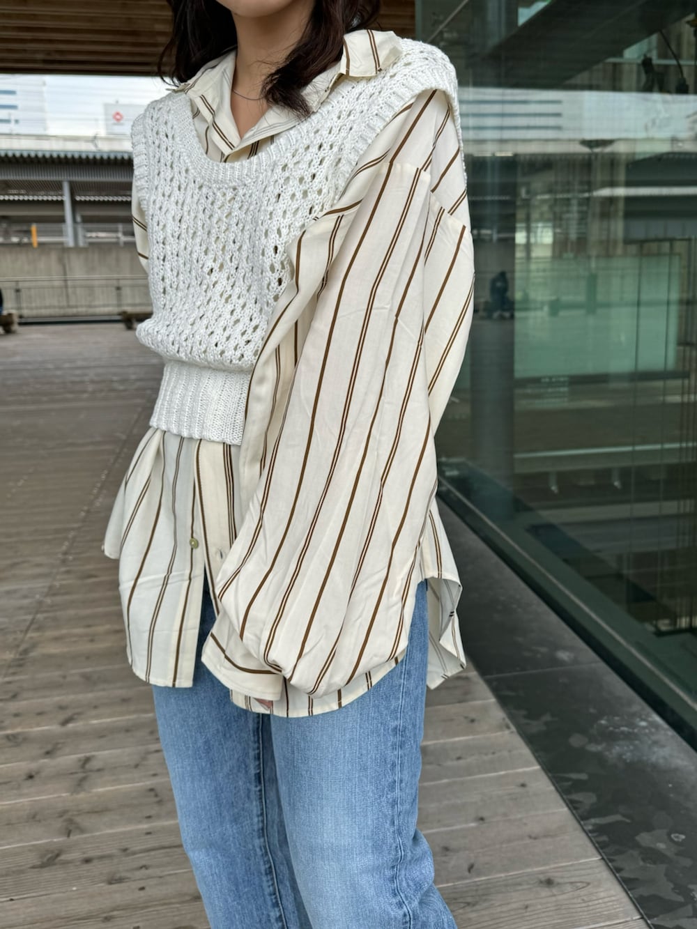 ベージュ系のブーツ、ブルー系のデニムパンツ、イエロー系のシャツ/ブラウスを着用したレディースの冬コーディネートの7枚目の写真