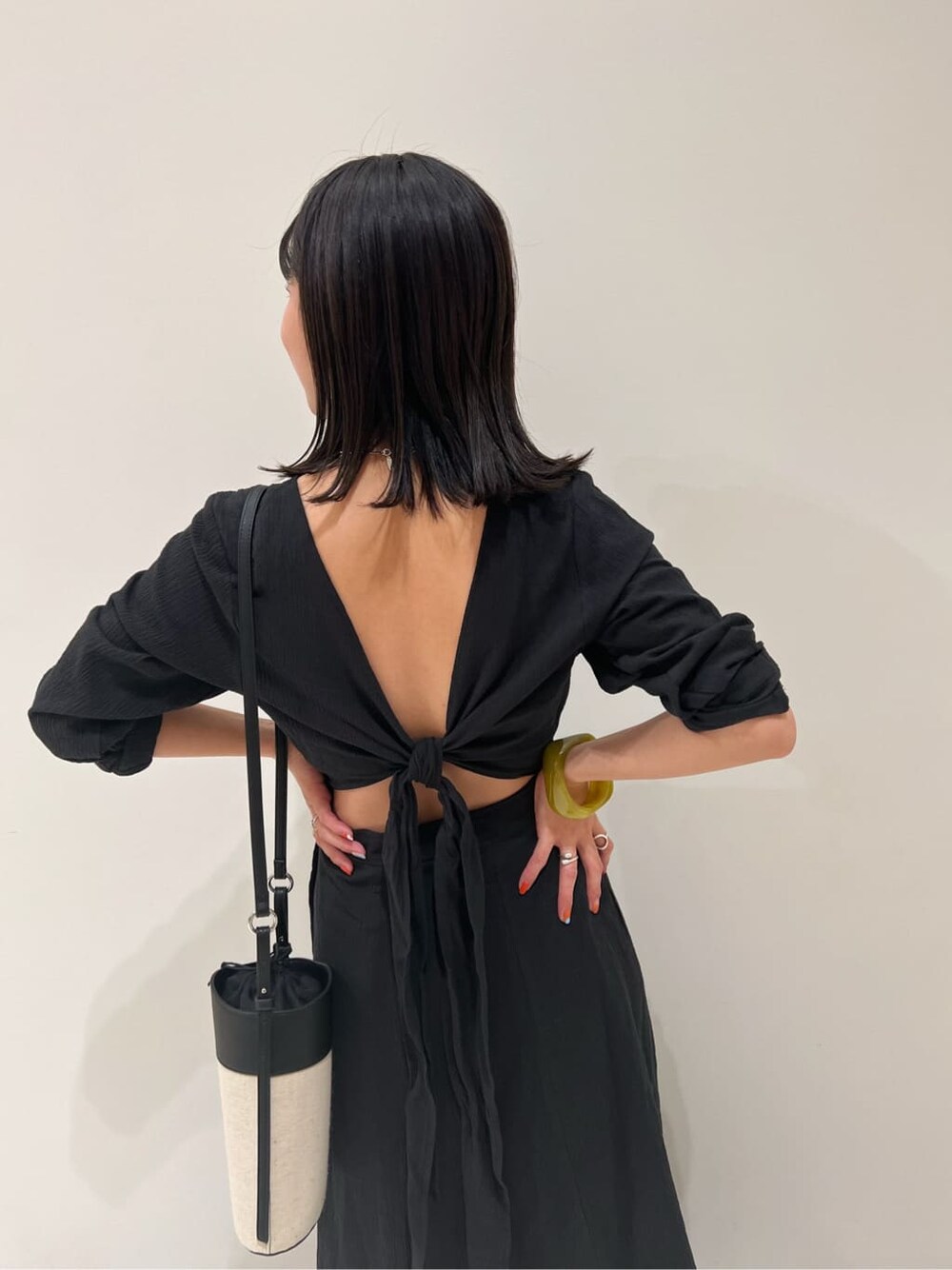 ブラック系のワンピース、ブラック系のショルダーバッグ、ブラック系のサンダルを着用したレディースの春コーディネートの6枚目の写真