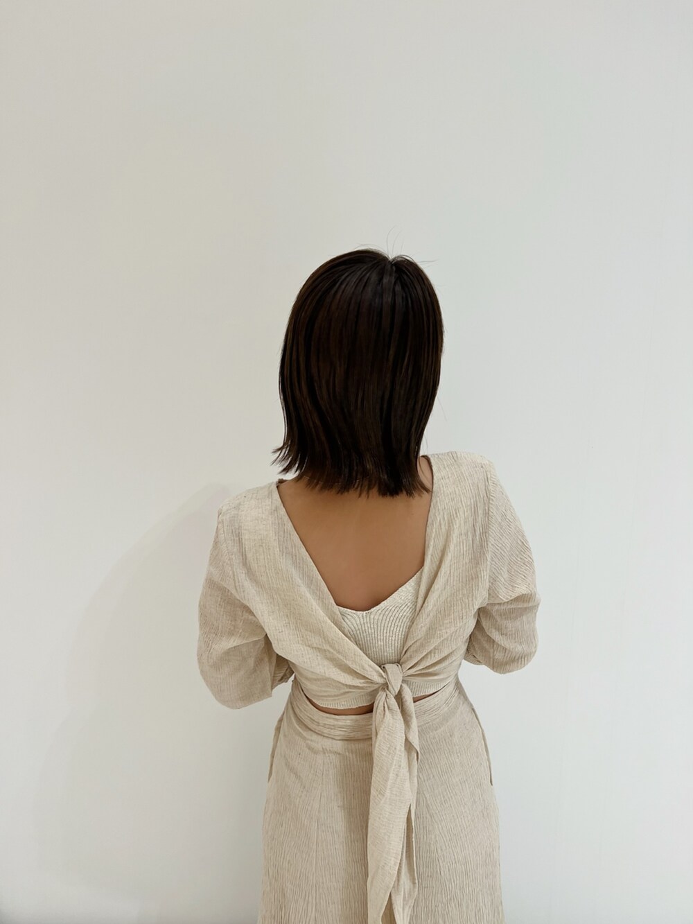 ホワイト系のベスト、ホワイト系のワンピース、ホワイト系のハンドバッグを着用したレディースの春コーディネートの10枚目の写真