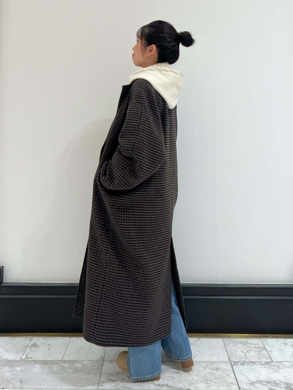 ベージュ系のブーツ、ブルー系のデニムパンツ、その他のチェスターコートを着用したレディースの冬コーディネートの8枚目の写真