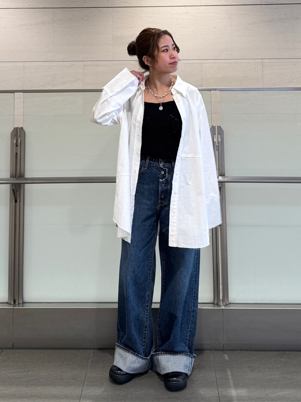 ブルー系のデニムパンツ、ホワイト系のシャツ/ブラウス、ブラック系のシャツ/ブラウスを着用したレディースの冬コーディネートの5枚目の写真