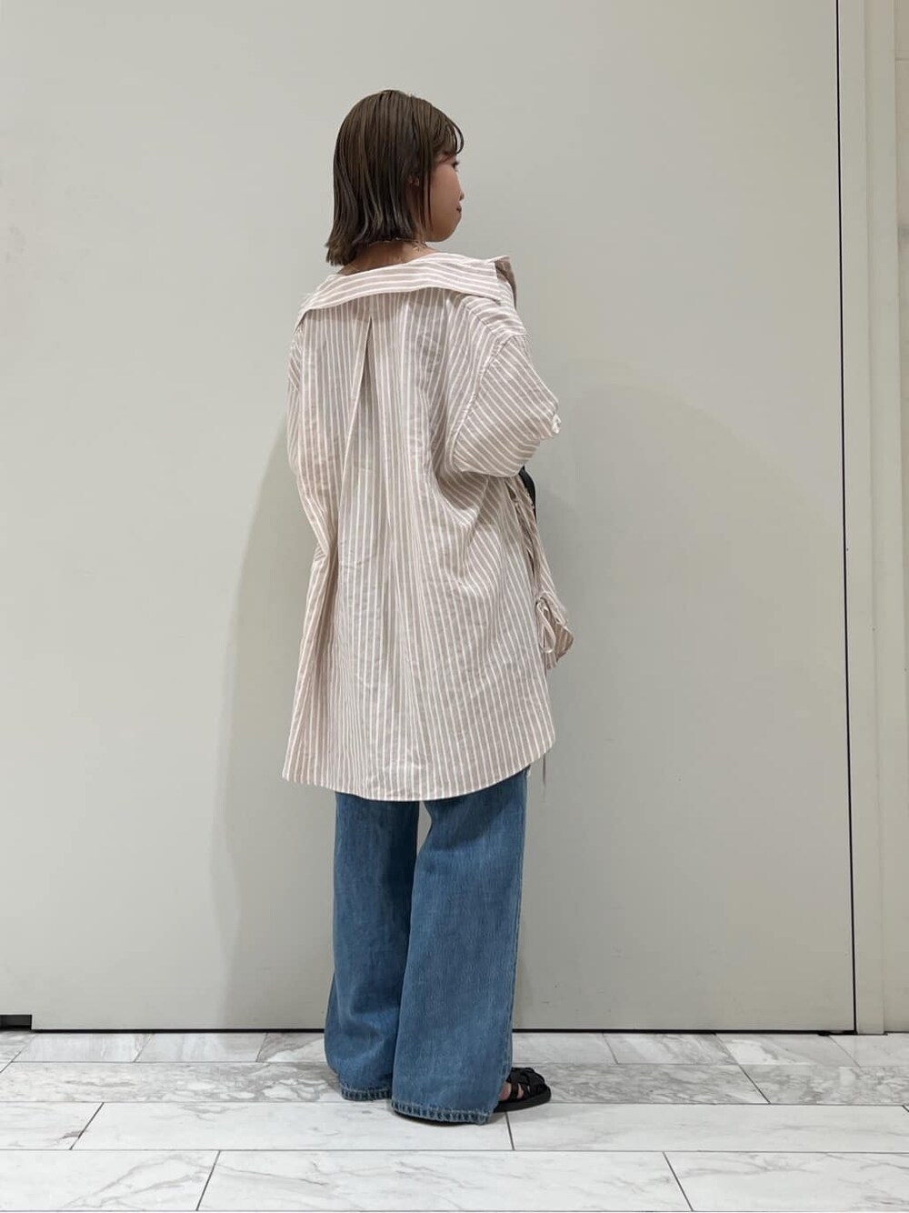 ブラック系のサンダル、ピンク系のシャツ/ブラウス、ブラック系のハンドバッグを着用したレディースの春コーディネートの4枚目の写真