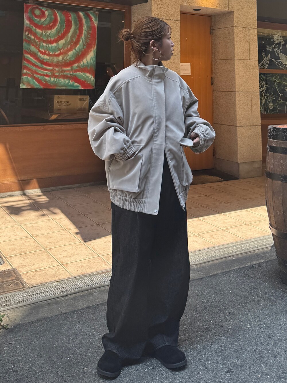 ベージュ系のブルゾン、ブラック系のデニムパンツ、ブラック系のスリッポンを着用したレディースの秋コーディネートの2枚目の写真