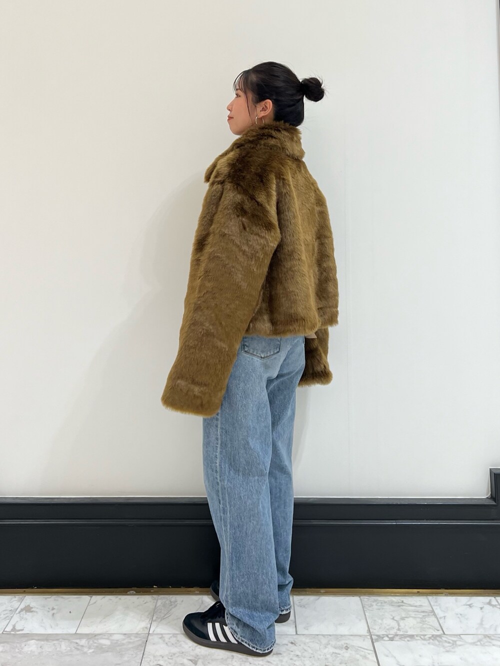 ブルー系のデニムパンツ、ブラウン系のブルゾン、レッド系のニット/セーターを着用したレディースの冬コーディネートの4枚目の写真