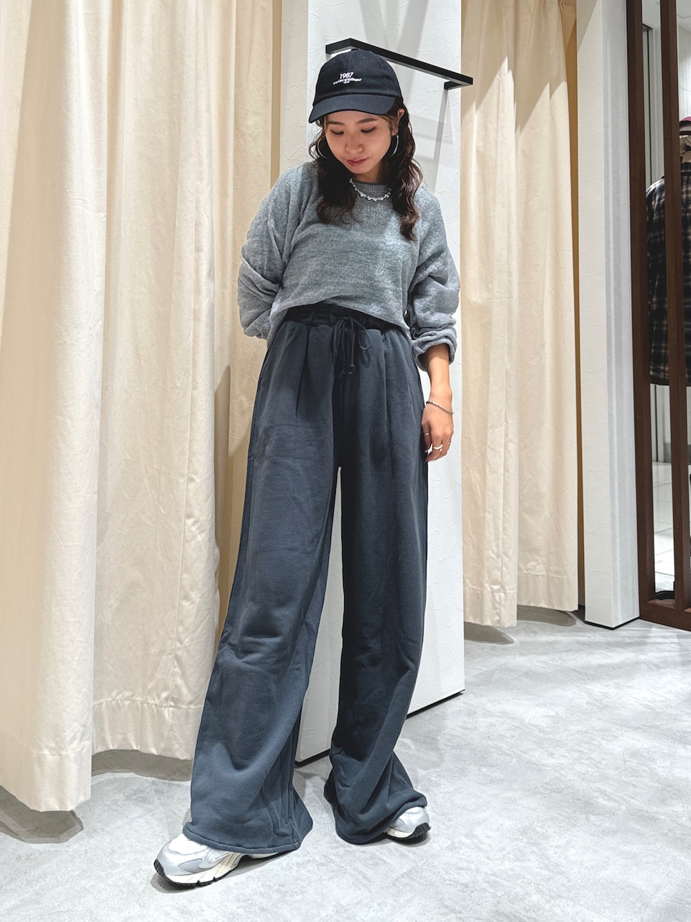 グレー系のニット/セーター、グリーン系のTシャツ/カットソー、グレー系のスウェットパンツを着用したレディースの秋コーディネートの2枚目の写真