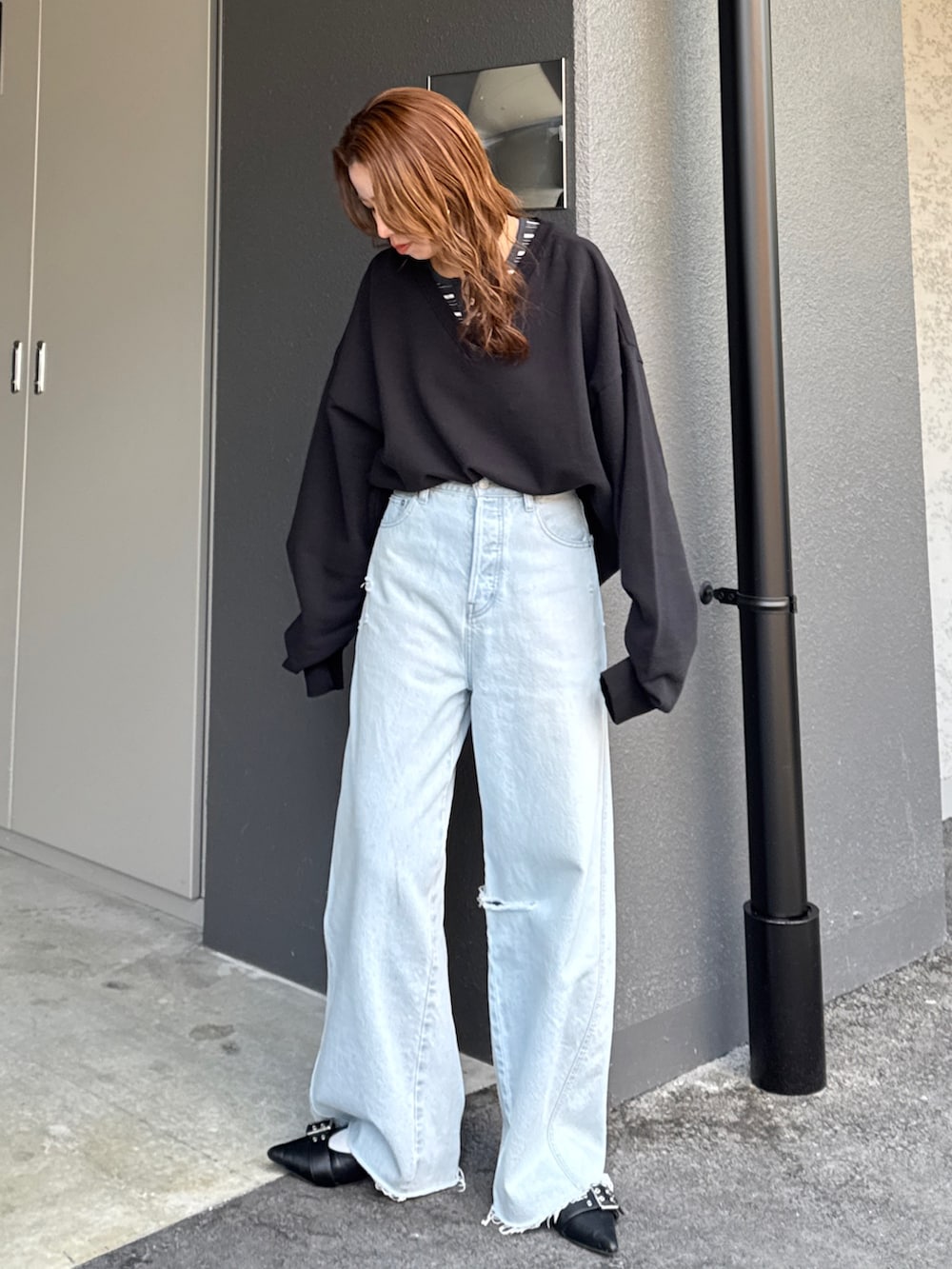 ブラック系のスウェット、グレー系のTシャツ/カットソー、ブルー系のデニムパンツを着用したレディースの春コーディネートの6枚目の写真