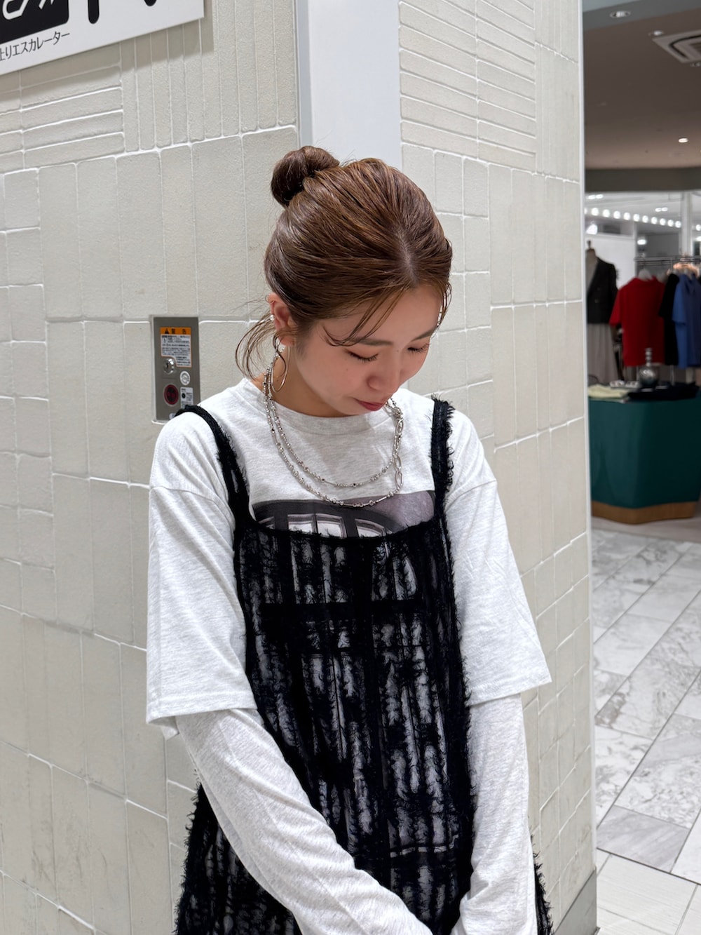 ブラック系のワンピース、グレー系のTシャツ/カットソー、ブルー系のデニムパンツを着用したレディースの春コーディネートの8枚目の写真