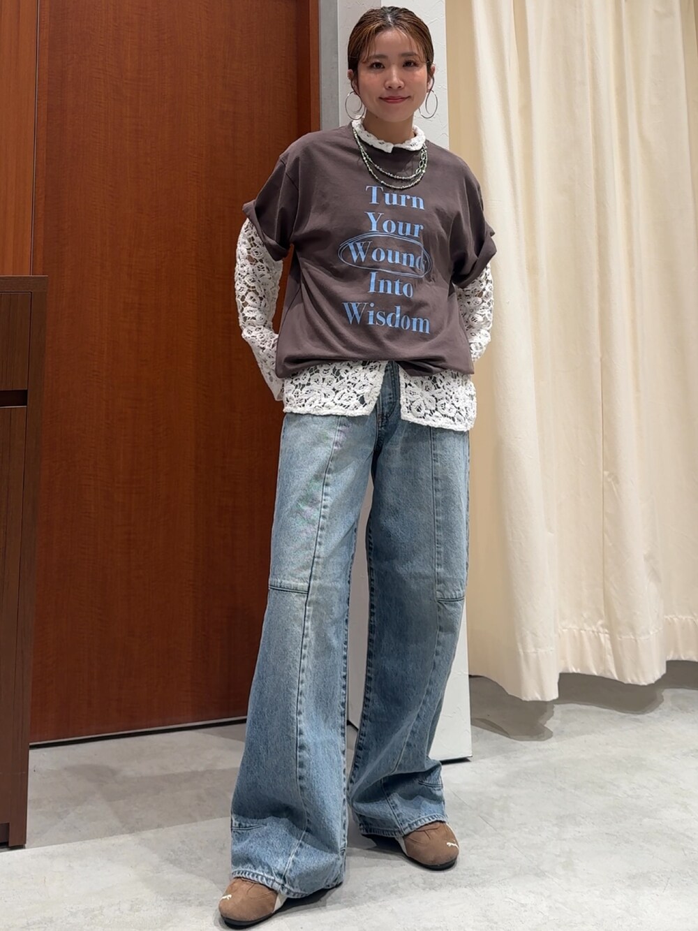 ブルー系のデニムパンツ、ブラウン系のTシャツ/カットソー、ホワイト系のシャツ/ブラウスを着用したレディースの春コーディネートの2枚目の写真