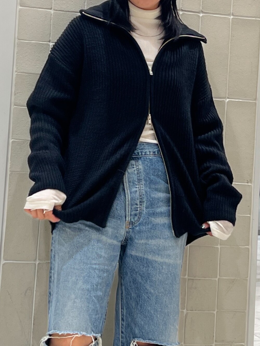 ブルー系のデニムパンツ、ブラック系のカーディガン/ボレロ、ホワイト系のTシャツ/カットソーを着用したレディースの秋コーディネートの6枚目の写真