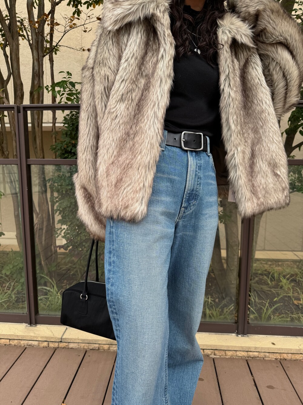 ベージュ系のその他アウター、ブルー系のデニムパンツ、ブラック系のハンドバッグを着用したレディースの秋コーディネートの8枚目の写真