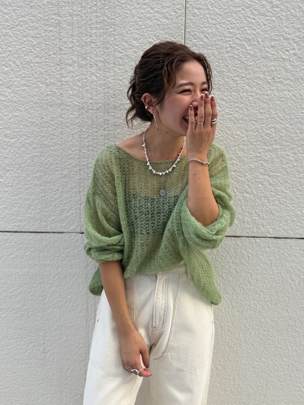 ホワイト系のデニムパンツ、グリーン系のニット/セーターを着用したレディースの秋コーディネートの6枚目の写真