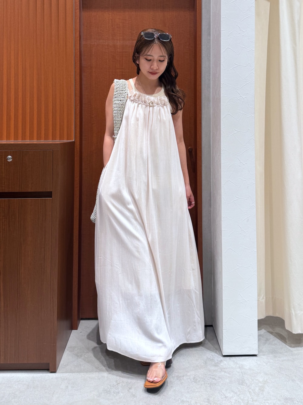 グレー系のショルダーバッグ、ホワイト系のワンピース、その他のサンダルを着用したレディースの夏コーディネートの2枚目の写真